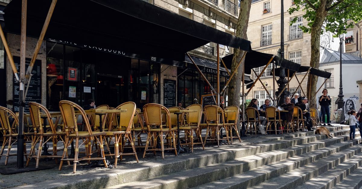 Outdoor Paris cafe with wicker chairs on stone steps