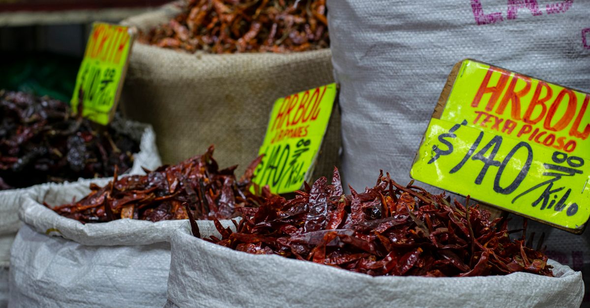 Sacks of dried chilies with handwritten price tags at a Mexican market