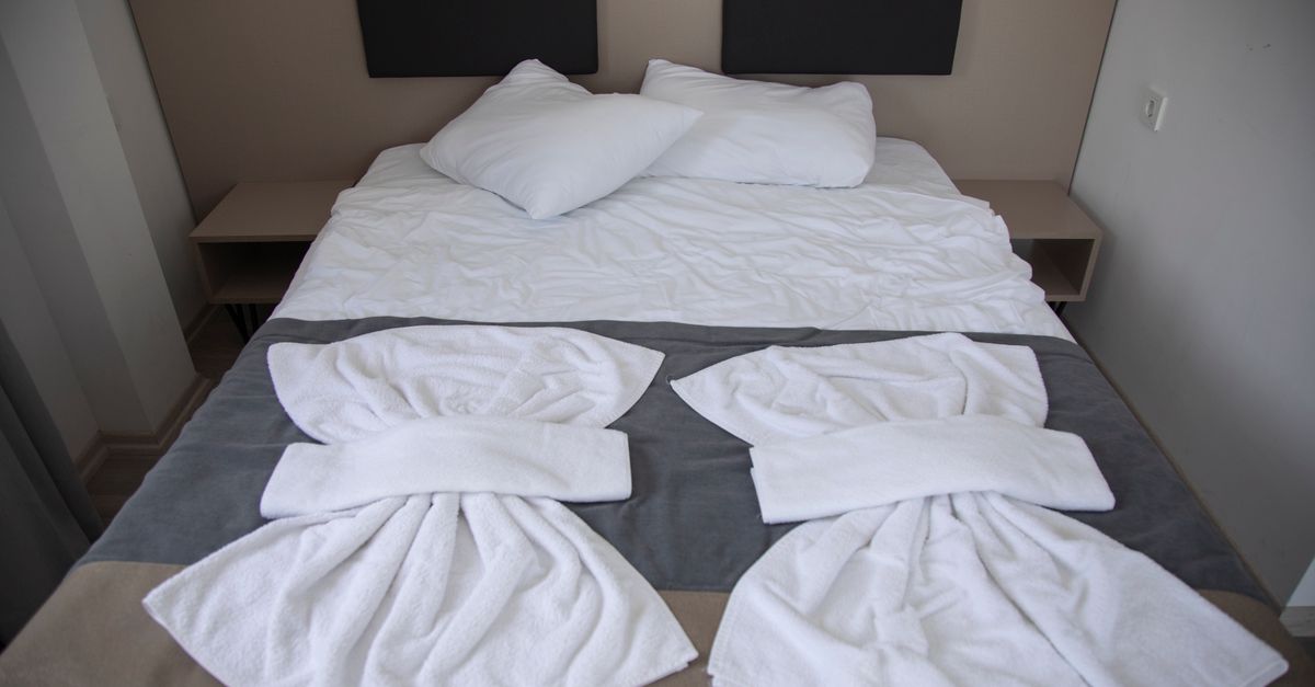 Hotel bed with neatly folded towel art