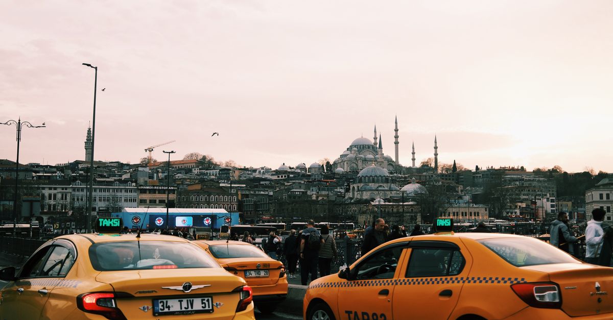 Yellow taxis in Istanbul traffic with a mosque in the background
