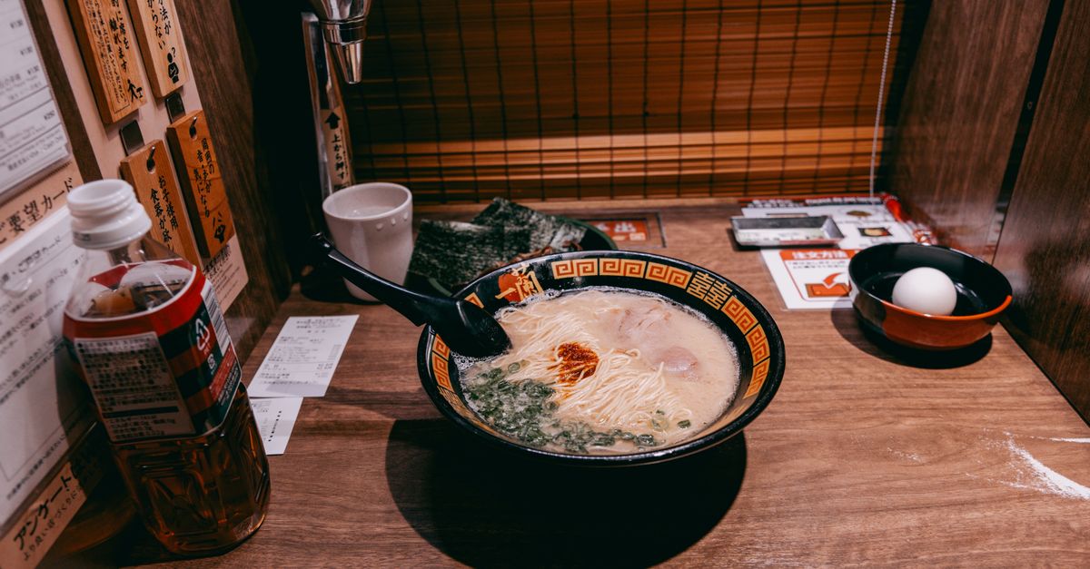 A steaming bowl of ramen in a private dining booth, typical of affordable Tokyo eateries.