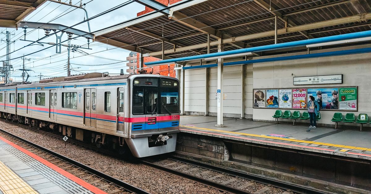 A commuter train arriving at a Tokyo railway station platform.